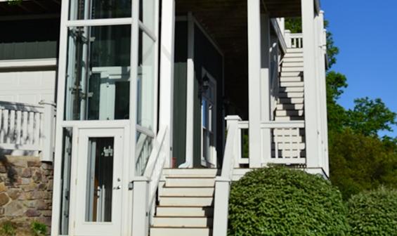 Outdoor pneumatic elevator next to patio staircase